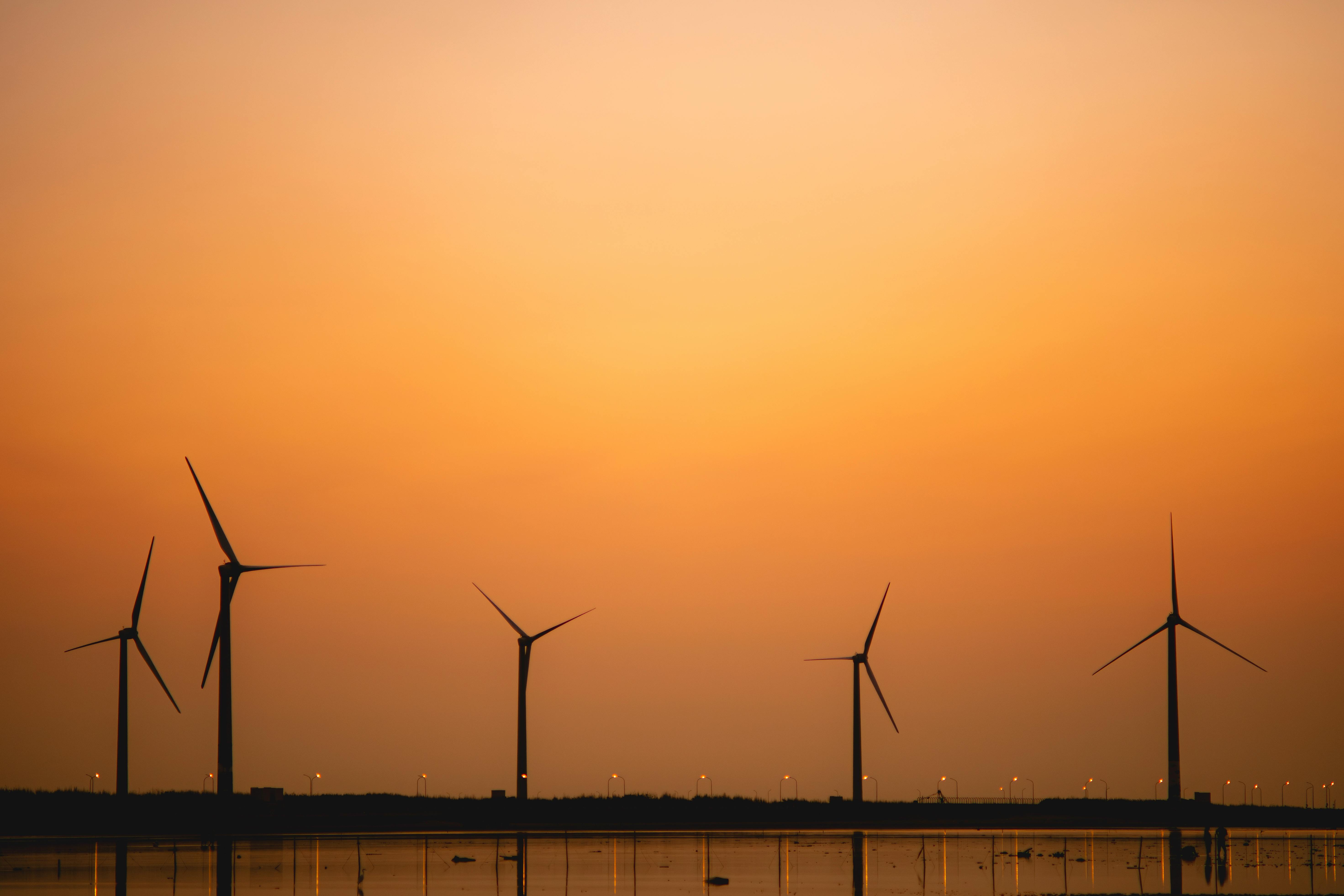 Windmills in the sea with a beautiful sunset behind